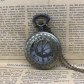 Vintage bronze pocket watch with Roman numerals on an antique newspaper background - Hollow Out / Bronze