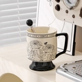 Close-up of vintage ceramic mug with rose floral patterns and a black spherical handle spoon - Black Rose (Boxed) + Spoon