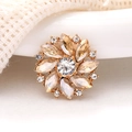 Macro view of golden flower brooch with champagne crystals and sparkling white rhinestones - Champagne