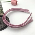 Detail view of pink sequin headbands with glitter finish and protective end caps - Nude