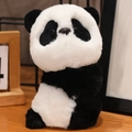Cute panda plush snap bracelet toy in black and white soft fur on wooden table - Sitting Panda