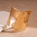 Detail van brede goudkleurige gehamerde armband met asymmetrische uitsnijdingen - Goud
