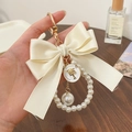 Elegant beige bow keychain with pearl strap and golden metal ring for bag accessories - Off White