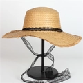 Detail of natural straw hat featuring frayed edges and a decorative black lace ribbon tie - Khaki With Black Lace