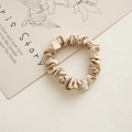 Detail shot of a champagne silk satin scrunchie with soft sheen and pleated texture - 6cm Satin Light Coffee