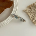 Detail of a handmade marble acetate hair clip with golden France engraving on white plate - Light Blue Oil Painting