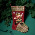 Red Christmas stocking with snowman applique and green plaid details on pine background - Snowman