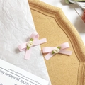 Dettaglio dei fermagli per capelli con fiocco rosa e rose in tessuto su vassoio decorato - Rosa