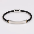 Detalle de pulsera de cuero negro trenzado con placa de plata y toques metálicos oro - Color Acero