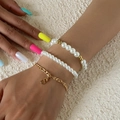Three-piece layered bracelet set with white pearls and a gold S pendant on model's wrist - Gold (2424)