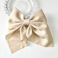 Elegant champagne-colored bow hair clip in matte satin fabric on a white background - Light Khaki