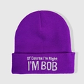 Close-up detail of white embroidery text on a purple ribbed knit beanie hat - Dark Purple