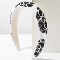 Detailaufnahme des handgefertigten Perlenstirnbands mit schwarz-weißen Leopardenmuster - Schwarzer Hintergrund Weißes Blumenmuster / Weiß
