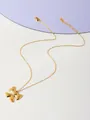 Dettaglio ravvicinato di una collana dorata con ciondolo a fiocco e chiusura a moschettone - Pendaglio a fiocco dorato-Catena sottile