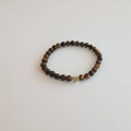 Bracelet en perles d'oeil de tigre avec un pendentif coeur doré sur fond blanc pur - Bracelet Oeil de Tigre 6MM