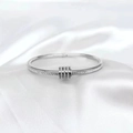 Silver stainless steel bangle with pave diamonds and three sliding ring charms on silk - Steel