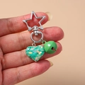 Dettaglio della chiusura a stella d'argento con cuore di paillettes verdi e campanello - Verde