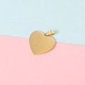 Macro view of polished golden heart-shaped pendant with metal ring on dual-tone background - 18K Gold Plated