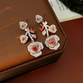 Detailed macro view of vintage rose earrings featuring red zircon and silver petals - Rose Drop Style / Silver/Red