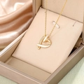 Elegante goldene Herzkette mit weißem Emaille und Diamanten auf Seidenpräsentation - Gold Weiß