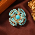 Ethno-Blumenbrosche mit türkisfarbenen Perlen und goldener hohler geometrischer Metallbasis - Künstliche Türkis Friedensknoten-Türkisblau