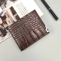 Vue détaillée de la texture crocodile marron foncé sur un portefeuille bi-fold pour homme - Café Foncé