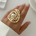 Golden irregular wavy ring with white pearl on model's finger in artistic setting - One Size (Adjustable Open) / Light Gold (0782 Irregular Pearl)