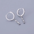 Macro detail of S925 silver hoop earrings with triple star pendants and zircon stones - Star Dangle - Silver