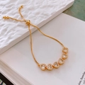Detail van verstelbare gouden hartarmband met sprankelende zirkoon en bolo-sluiting - Goud/Witte Zirconia