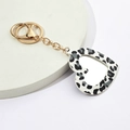Llavero de corazón con estampado de leopardo y gancho de metal dorado en fondo blanco - Negro & Blanco