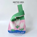 Close-up of a floral knitted bucket bag featuring colorful patchwork and white flower motifs - Green Pink Small Flowers