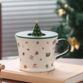 Detail of Santa Claus ceramic mug with Christmas tree lid on a notebook and festive background - Christmas Gift (With Lid)