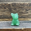 Macro shot of 3cm green semi-precious stone french bulldog carving on wooden surface - Green Aventurine
