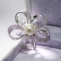 Vista macro di spilla a fiore argento con perla bianca e zirconi micro-pavé - Bianco