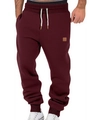Front view of maroon joggers featuring a black elastic waistband and white drawstrings - Burgundy