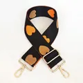 Macro detail of adjustable nylon bag strap with woven heart pattern and gold metal hooks - No. 31 + Gold Hook (Black with Orange/Coffee Heart)