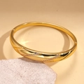 Detailed view of 18k gold plated bangle with twisted design and cubic zirconia inlay - Gold (18K Gold Plated)