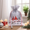 Christmas burlap gift bag with gnome print and red drawstring on a cozy wooden table - Grey Three Gnomes