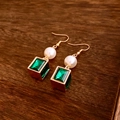 Detail of vintage gold pearl and green crystal earrings on a dark wood texture background - Hook Earrings (Gold-Green-White)