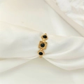Macro detail of a gold ring featuring three black gemstones and vintage embossed textures - Adjustable Open / Gold Black Zirconia