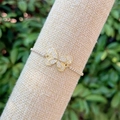 Vista macro del bracciale a farfalla placcato oro 18k con zirconi colorati su supporto in lino - Farfalla in Zircone Bianco Micro-incastonato(3)