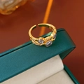 Detail of vintage gold open ring with three circular coin reliefs on green jewelry box - Gold and Silver Two-Tone Vintage Coin Open Style