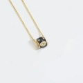 Golden necklace with black enamel doughnut pendant featuring an evil eye motif - Black Evil Eye