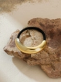 Detail of a black elastic hair tie featuring a polished gold crescent metal ornament - Golden Crescent