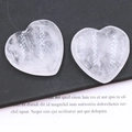Transparent 40mm natural crystal heart worry stones on open book background - White Crystal