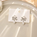 Elegant silver bow earrings with sparkling crystals and hanging pearls for women - Silver