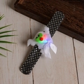 Close-up of a white ghost Halloween LED slap bracelet with sparkly black sequins - Glowing Ghost