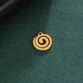 Makroaufnahme eines 18K vergoldeten Edelstahl-Spiralanhängers auf grünem Grund - Kreisförmiges Spiralmuster / Gold