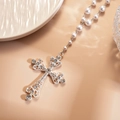 Dettaglio del ciondolo a croce argento con strass su una collana di perle bianche - Croce d'Argento (Set da Due Pezzi)