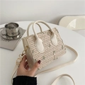 Borsa in paglia con ricamo floreale verde e tracolla su scrivania bianca - Bianco Sporco